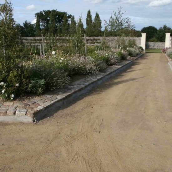 Photos du jardin potager de La Baronnière : le thème gris et blanc depuis l'allée centrale et le verger à gauche